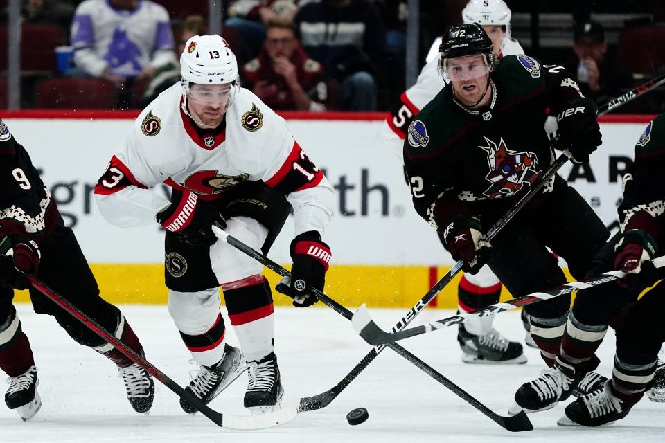 Ottawa Senators left wing Zach Sanford (13) skates with the puck in front of Arizona Coyotes center Travis Boyd (72) during the second period of an NHL hockey game Saturday, March 5, 2022, in Glendale, Ariz. (AP Photo/Ross D. Franklin)