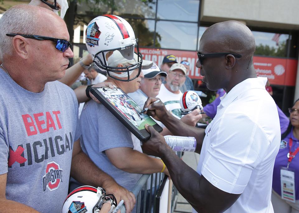 Pro Football Hall of Fame Class of 2017 enshrinee Terrrell Davis signs autographs for fans Friday along Market Avenue in Canton.