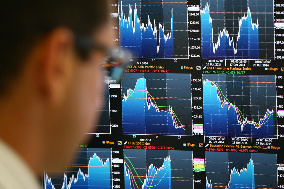 An employee views trading screens at the offices of Panmure Gordon and Co. Photo by Carl Court/Getty Images