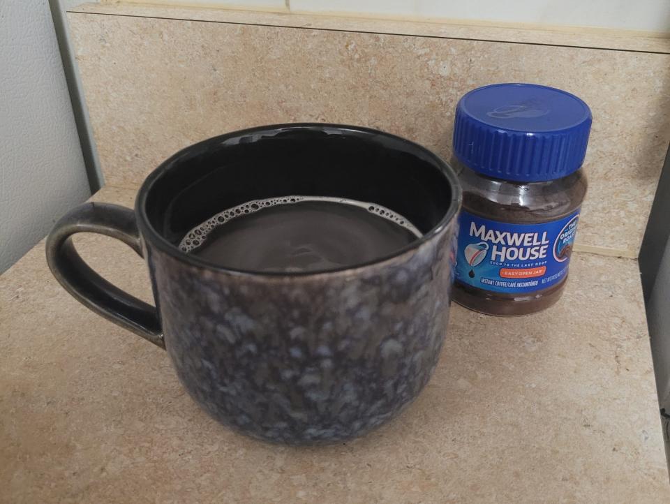 maxwell house instant coffee next to a cup of prepared coffee