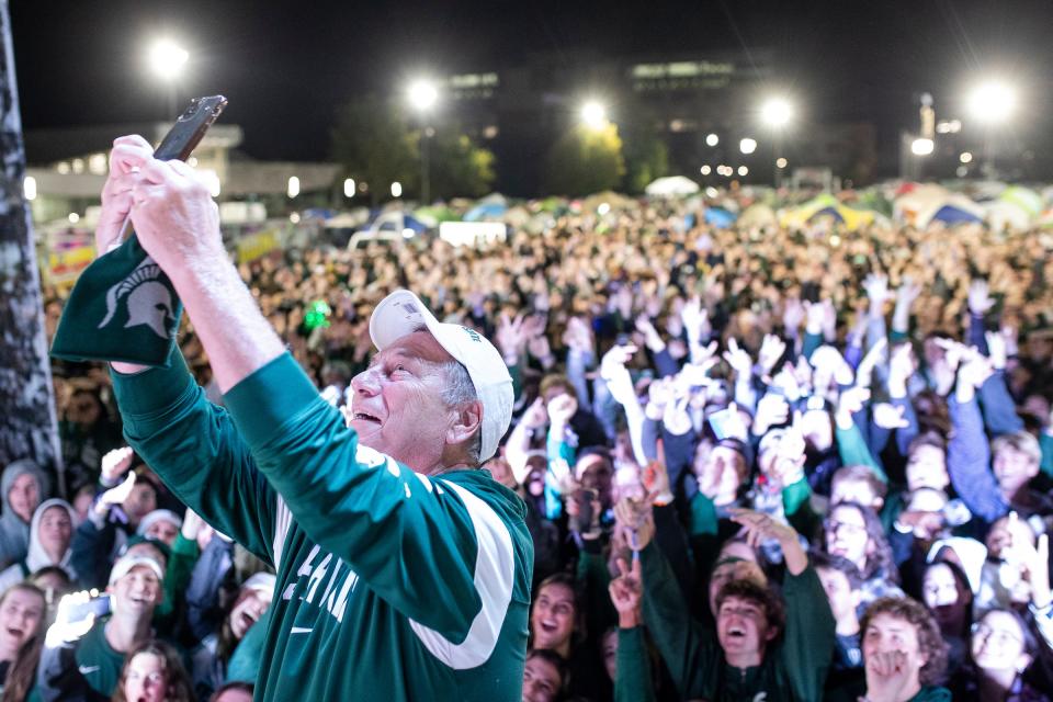 MSU men's basketball head coach Tom Izzo takes a selfie with fans from the stage during Izzone Campout at Munn Field near Breslin Center in East Lansing on Friday, Oct. 6, 2023.