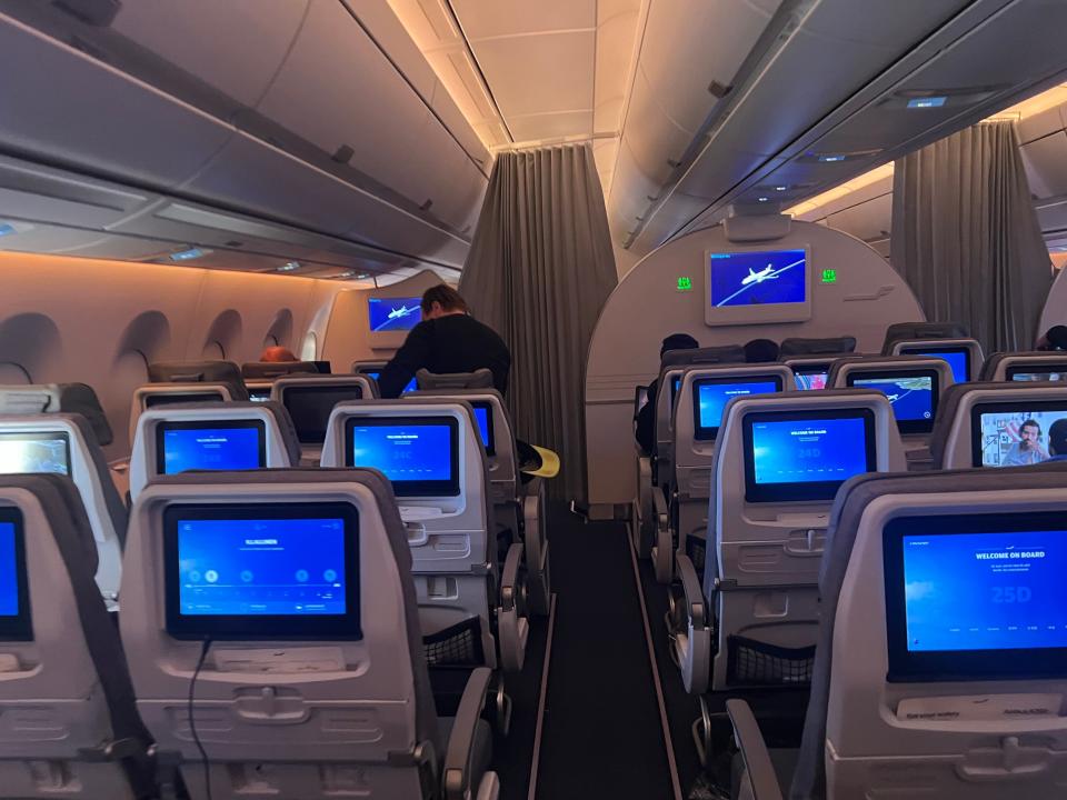 The cabin of the Finnair A350 with blue screens showing.