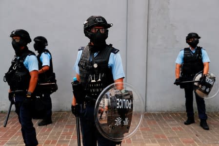 Riot police stand guard during a march to demand democracy and political reforms, at Kowloon bay, in Hong Kong