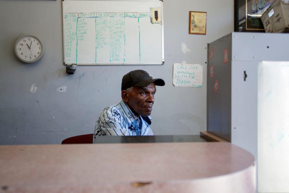 Property manager Jeffrey Young sits behind the front desk of the former dormitory building in San Bernardino, Calif., on October 5, 2022. The unpermitted housing complex is shutting down, displacing hundreds. 
