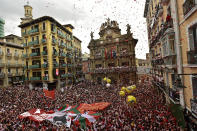 Revelers fill the town hall square waiting for the launch of the 'Chupinazo' rocket, to mark the official opening of the 2022 San Fermin fiestas in Pamplona, Spain, Wednesday, July 6, 2022. The blast of a traditional firework opens Wednesday nine days of uninterrupted partying in Pamplona's famed running-of-the-bulls festival which was suspended for the past two years because of the coronavirus pandemic. (AP Photo/Alvaro Barrientos)
