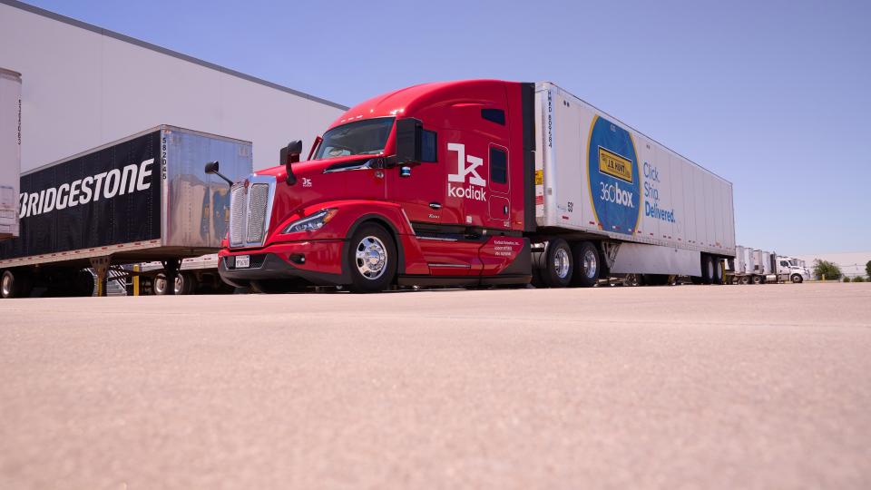 A red Kodiak truck with a 360box trailer at a Bridgestone facility