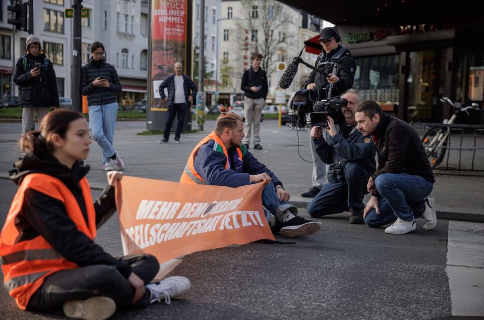 Aktivisten der Letzten Generation werden bei einer Straßenblockade interviewt. Nur 13 der Deutschen halten diese Art des Protests für gerechtfertigt. (Bild: SWR / Gordon Welters)