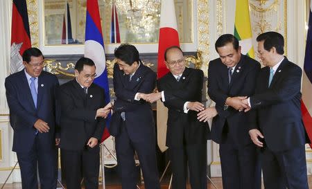 (L-R) Cambodia's Prime Minister Hun Sen, Laos' Prime Minister Thongsing Thammavong, Japan's Prime Minister Shinzo Abe, Myanmar President Thein Sein, Thailand's Prime Minister Prayuth Chan-ocha and Vietnam's Prime Minister Nguyen Tan Dung, join hands for a group photo, prior to the 7th Mekong-Japan Summit meeting at the Akasaka State Guest House in Tokyo, July 4, 2015. REUTERS/Koji Sasahara/Pool
