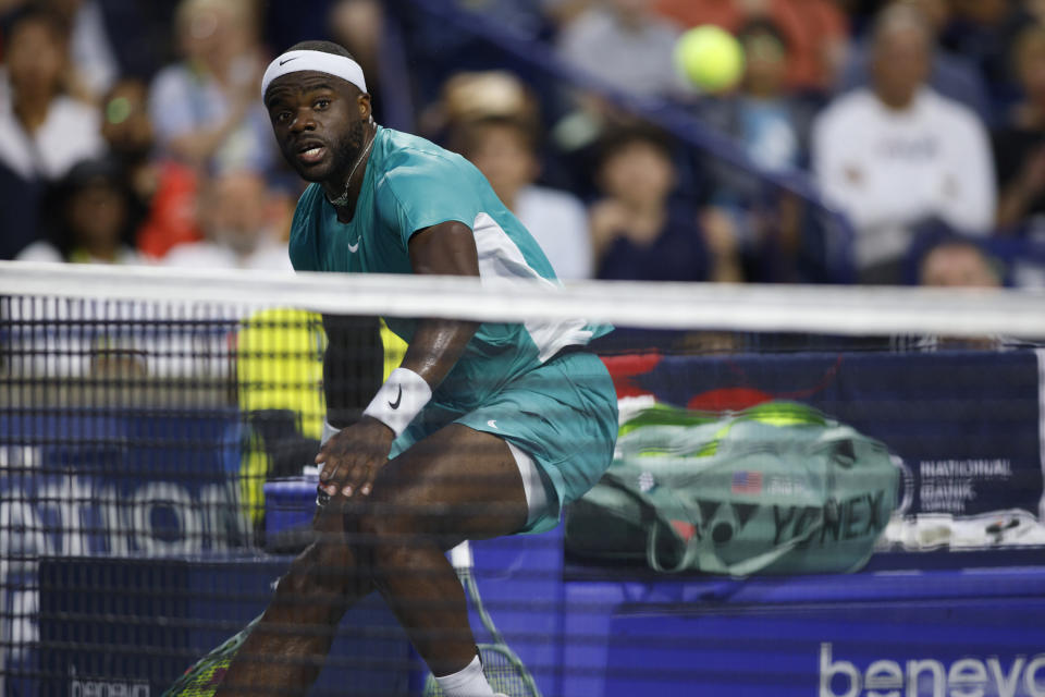 Frances Tiafoe, of the Unied States, puts a ball over the net to win a tiebreaker of the first set against Canada's Milos Raonic during the first day of the men's National Bank Open tennis tournament in Toronto, Monday, Aug. 7, 2023. (Cole Burston/The Canadian Press via AP)