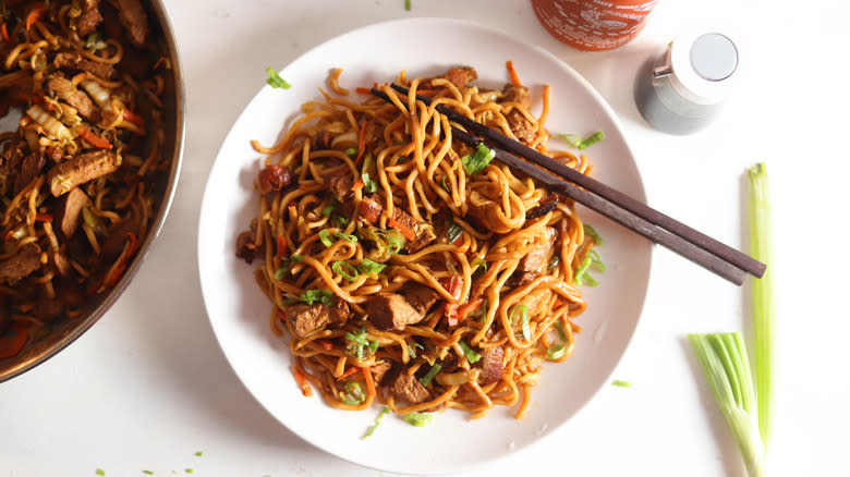 roasted pork lo mein with chopsticks on plate