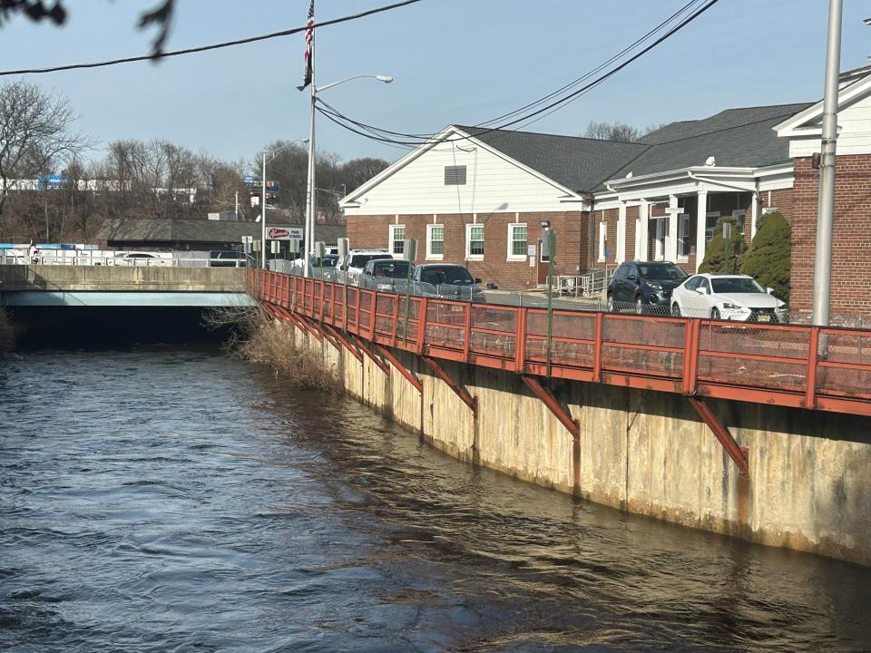 The Rockaway River flows past Dover Town Hall and the police station three days after a rain storm flooded the town and the Town Hall basement, causing $38,000 for remediation.