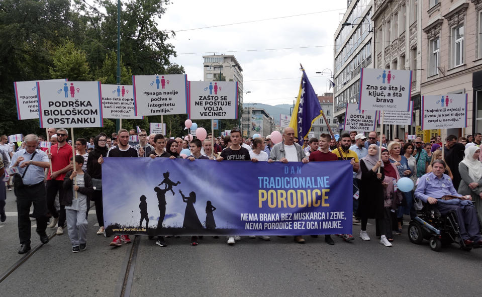 Holding banners and balloons, participants march in what they said was a gathering designed to promote traditional family values in Sarajevo, Bosnia, Saturday, Sept. 7, 2019. Several hundred people have marched in Bosnia's capital Sarajevo to express their disapproval of the Balkan country's first ever LGBT pride parade scheduled for Sunday. (AP Photo/Eldar Emric)