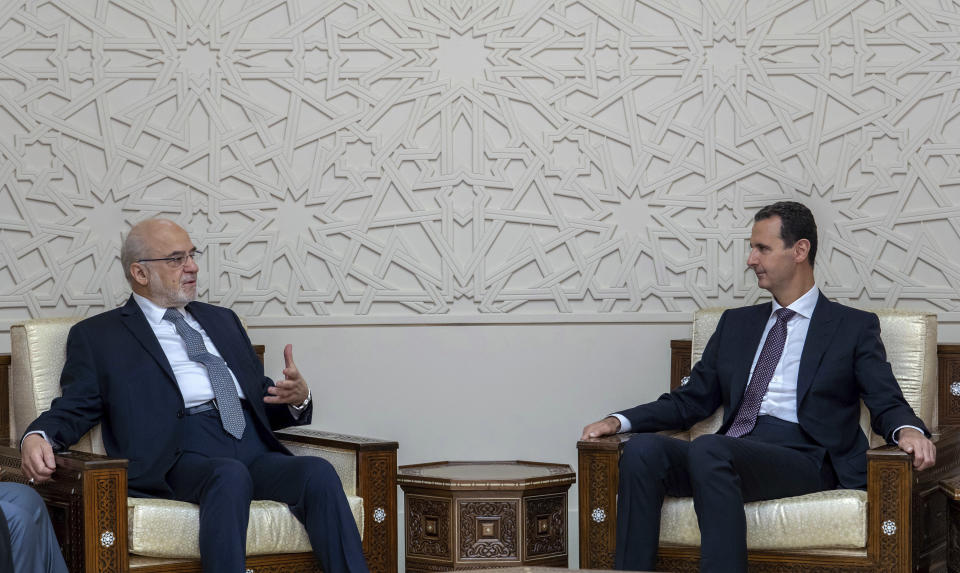 In this photo released by the Syrian official news agency SANA, shows Syrian President Bashar Assad, right, meeting with Iraqi Foreign Minister Ibrahim al-Jaafari, in Damascus, Syria, Monday, Oct. 15, 2018. Al-Jaafari said Syria should not be isolated from its Arab neighbors, and lauded Damascus for staying "strong" and united in the face of many adversities. (SANA via AP)