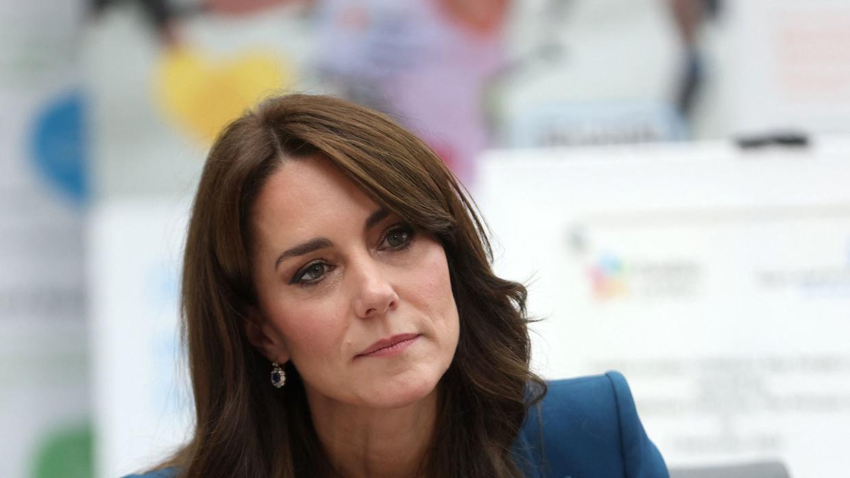 kate middleton sitting in a chair and looking pensively as she leans forward