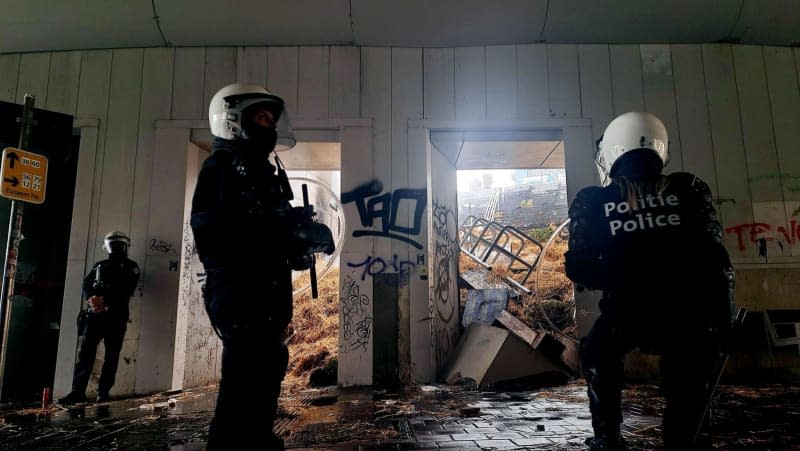 Police stand in the Maalbeek underpass, where the stairs are blocked by hay and trash thrown by farmers, during a protest against EU agricultural policy and demand improvements in their industry. Timon Ramboer/Belga/dpa