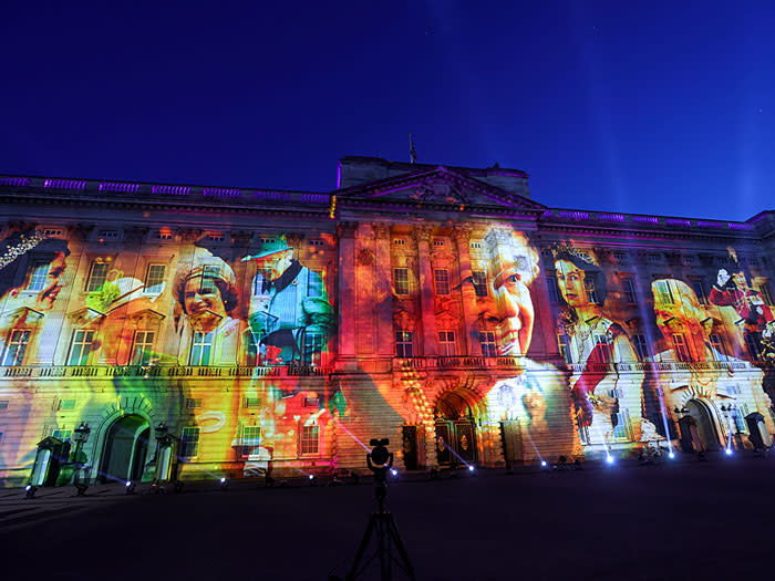 Imagen de una fachada iluminada con el retrato de Isabel II 