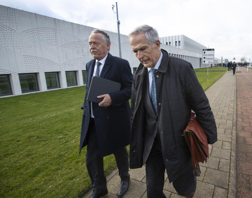 Piet Ploeg, left, who lost his brother, Alex, his sister-in-law and his nephew, and Anton Kotte, right, who lost his son, daughter-in-law and grandson, arrive at the court for the trial of four men charged with murder over the downing of Malaysia Airlines flight 17, at Schiphol airport, near Amsterdam, Netherlands, Monday, March 9, 2020. A missile fired from territory controlled by pro-Russian rebels in Ukraine in 2014, tore the MH17 passenger jet apart killing all 298 people on board. (AP Photo/Peter Dejong)