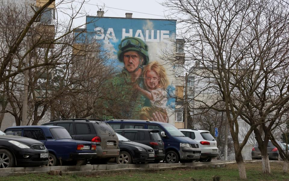 A mural of a Russian serviceman holding a child in his arms in Crimea