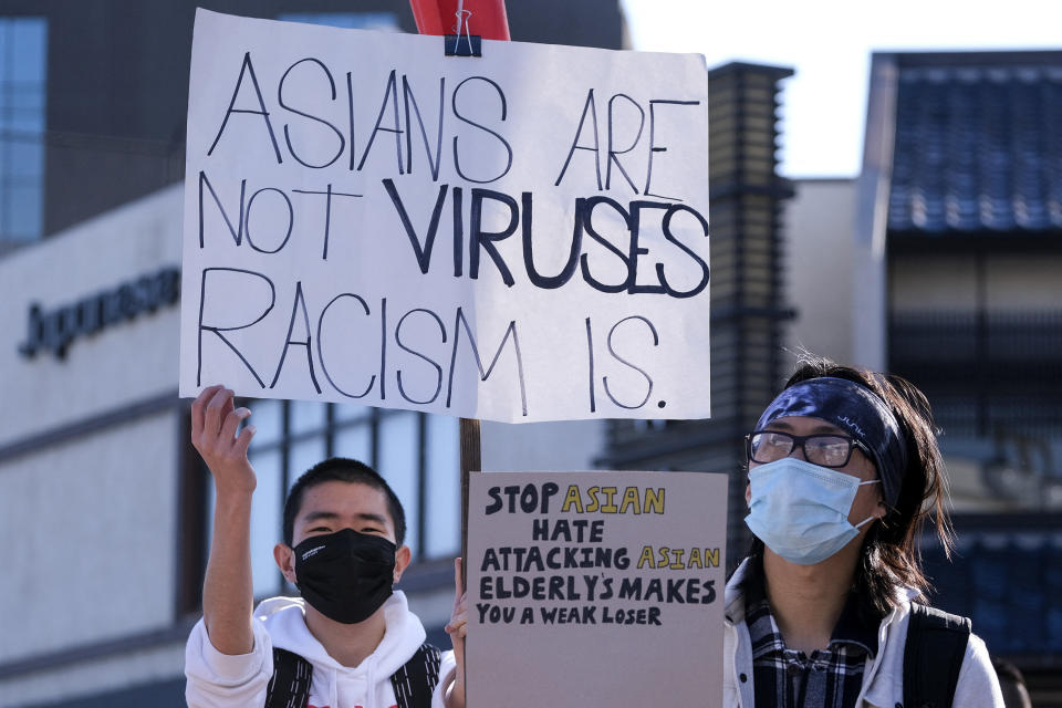 Demonstrators wearing face masks and holding signs take part in the rally "Love Our Communities: Build Collective Power" to raise awareness of anti-Asian violence at the Japanese American National Museum in Little Tokyo in Los Angeles in March. (Photo: RINGO CHIU via Getty Images)