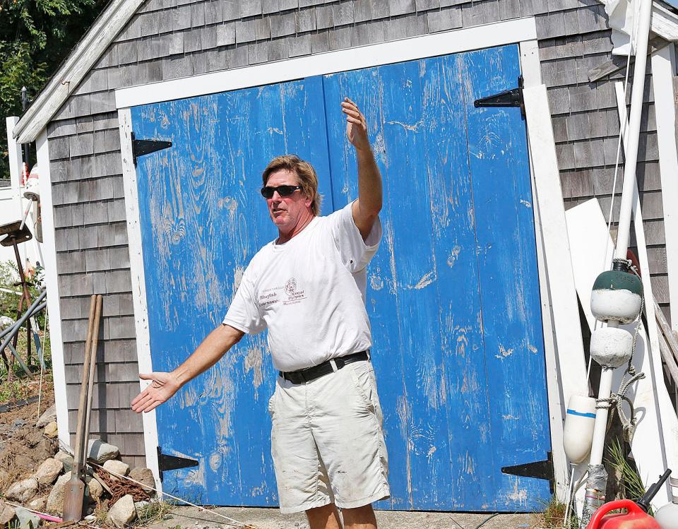 Marshfield lobsterman Andy Glynn helps guide his new boat into the driveway. His boat is named "Bre-Jay," and is 45 feet long and 17 feet wide. It required a state police escort from the New Hampshire border to Glynn's Brant Rock home on August 9, 2022.