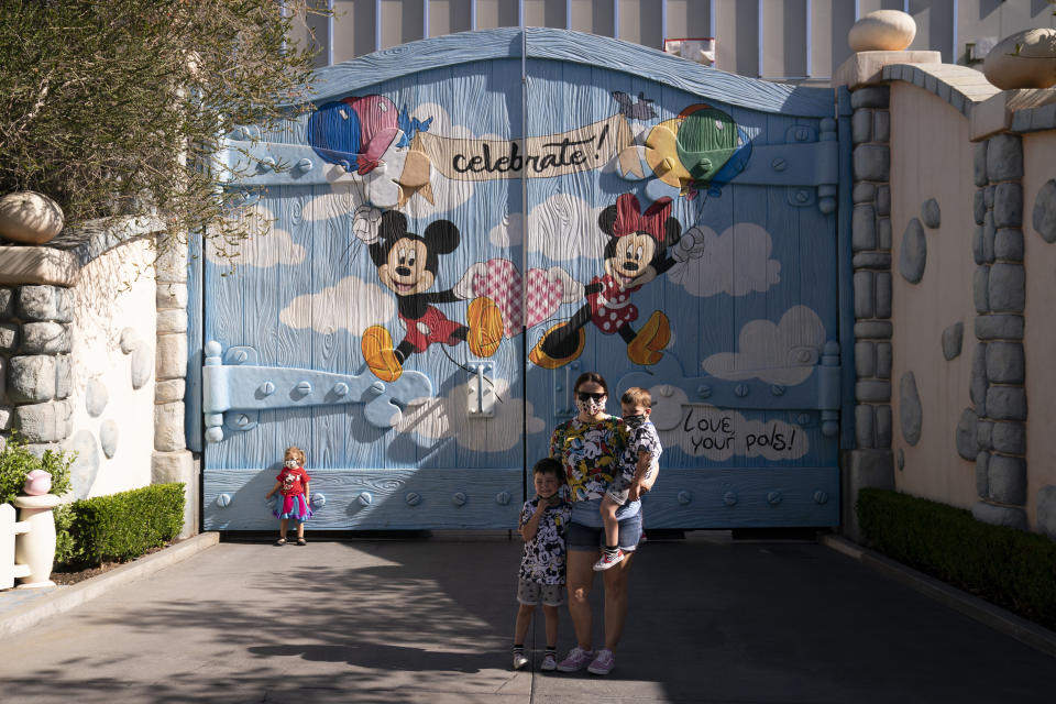 Guests take pictures at Mickey's Toontown in Disneyland at Disneyland in Anaheim, Calif., Friday, April 30, 2021. The iconic theme park in Southern California that was closed under the state's strict virus rules swung open its gates Friday and some visitors came in cheering and screaming with happiness. (AP Photo/Jae C. Hong)