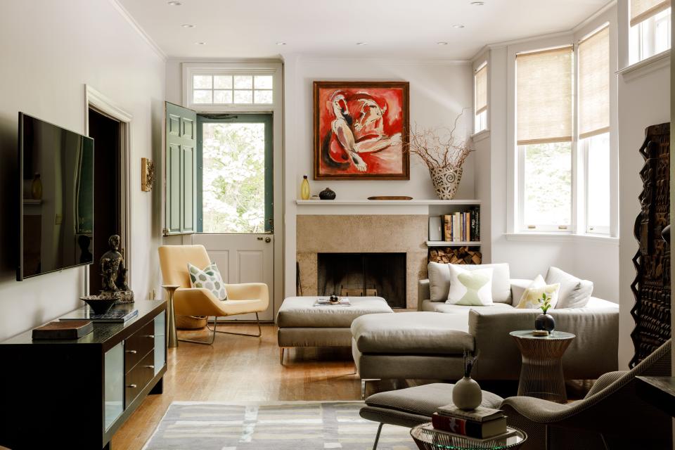 The family room is a cozy space filled with light. Note the Dutch door on the back wall, one of the couple’s favorite features of the home. The sectional, ottoman, and armchair are all custom-made by Picasero and paired with an Eero Saarinen Womb chair and matching ottoman. The custom wool-and-silk rug is from Classic Rug Collection and inspired by Gee’s Bend quilts. Leaning on the right wall is a hand-carved wooden door from Dogon, Mali.