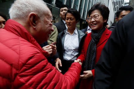 A man shakes hands with Carrie Lam, chief executive-elect, a day after she was elected in Hong Kong, China March 27, 2017.REUTERS/Bobby Yip