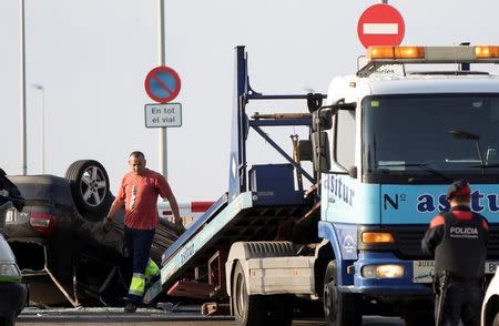 A worker loads a car on a tow truck where the police investigate the scene of an attack in Cambrils, south of Barcelona, Spain, August 18, 2017. REUTERS/Stringer