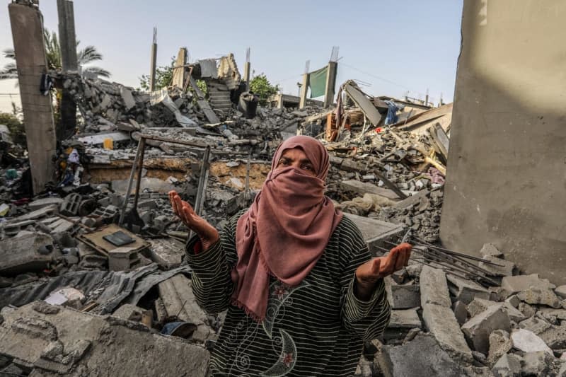 A Palestinian woman inspects a house that was destroyed after an Israeli aircraft bombed a home for the Al-Bakhabsa family, resulting in the death of 3 people and several wounded, in the city of Rafah, southern of the Gaza Strip. Abed Rahim Khatib/dpa