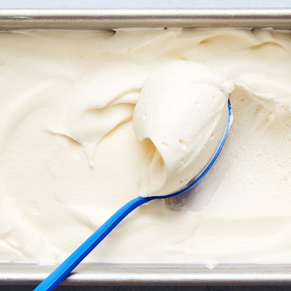 homemade soft serve ice cream in a loaf pan scooped with a blue spoon