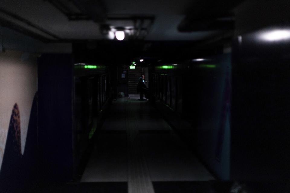 A subway employee stands in the hallways of Buenos Aires's subway lit only by emergency lights during a blackout, in Buenos Aires, Argentina, Sunday, June 16, 2019. Argentina and Uruguay were working frantically to return power on Sunday, after a massive power failure left large swaths of the South American countries in the dark. (AP Photo/Tomas F. Cuesta)