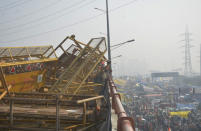 NEW DELHI, INDIA - JANUARY 26: Demonstrators removing police barricades while heading into the capital during a tractor rally on Republic Day, at Ghazipur on January 26, 2021 in New Delhi, India. Major scenes of chaos and mayhem at Delhi borders as groups of farmers allegedly broke barricades and police check posts and entered the national capital before permitted timings. Police used tear gas at Delhi's Mukarba Chowk to bring the groups under control. Clashes were also reported at ITO, Akshardham. Several rounds of talks between the government and protesting farmers have failed to resolve the impasse over the three farm laws. The kisan bodies, which have been protesting in the national capital for almost two months, demanding the repeal of three contentious farm laws have remained firm on their decision to hold a tractor rally on the occasion of Republic Day. (Photo by Sakib Ali/Hindustan Times via Getty Images)