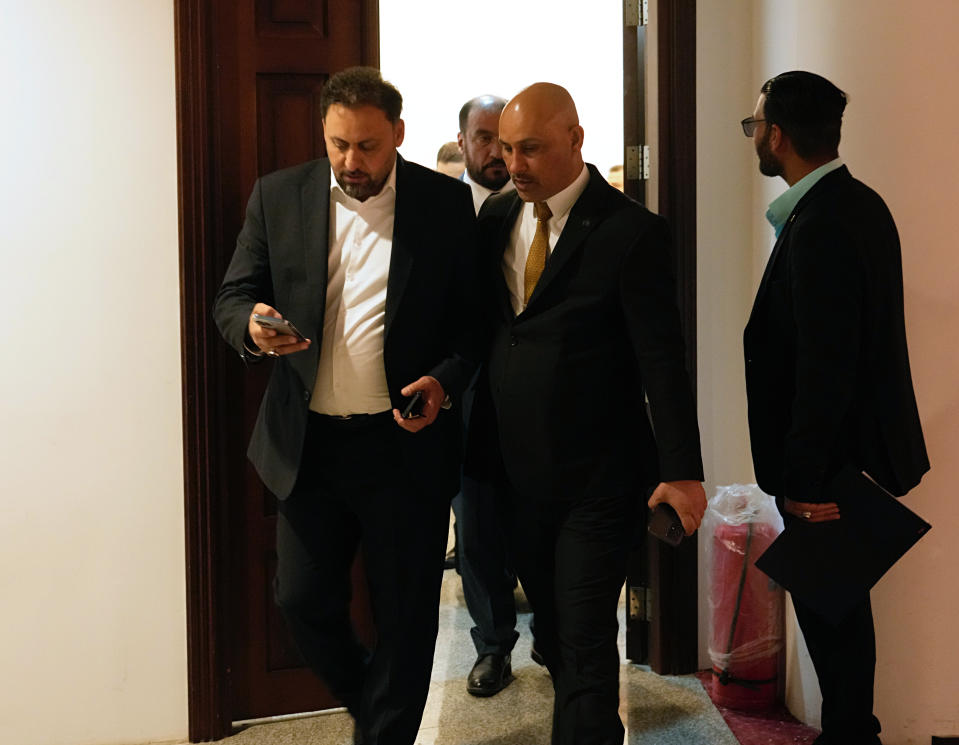 Lawmakers affiliated to Iraqi cleric Muqtada al-Sadr's parliamentary bloc prepare to attend a parliamentary session in Baghdad, Iraq, Wednesday, March 30, 2022. (AP Photo/Hadi Mizban)