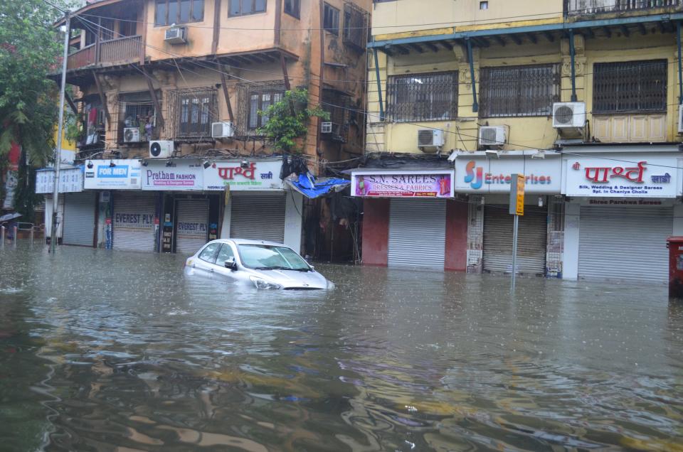 A car is stranded on a heavily flooded road in Mumbai. (Photo by Arun Patil)