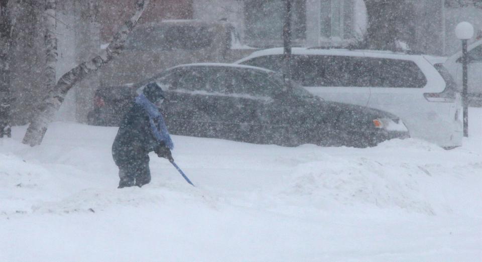 A person shoveling snow is nearly invisible in the whiteout conditions on Jan. 28, 2019, in Sheboygan, Wisconsin.