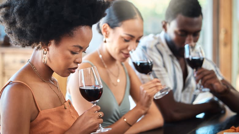 drinkers smelling wine in glasses