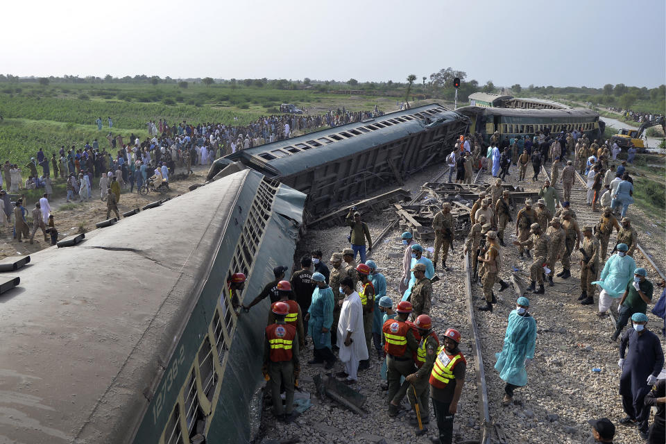 Rescue workers and army troops take in a rescue operation at the site of train derailed outskirts of Sarhari railway station Nawabshah, Pakistan, Sunday, Aug. 6, 2023. Railway officials say some passengers were killed and dozens more injured when a train derailed near the town of Nawabshah in southern Sindh province. (AP Photo/Pervez Masih)