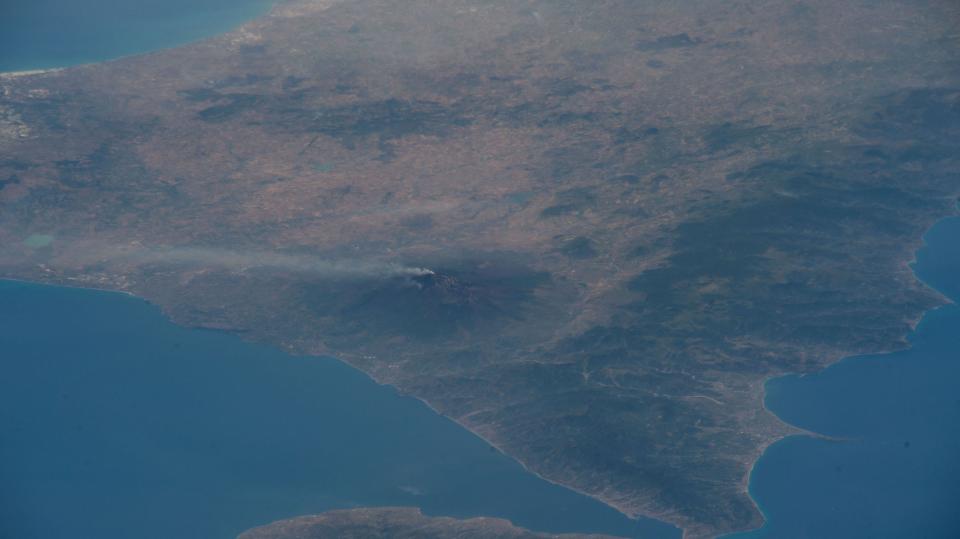 view from space mount etna volcano with steam billowing out