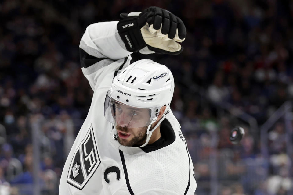 Los Angeles Kings center Anze Kopitar tries to grab the puck as it falls behind his head in the third period of an NHL hockey game against the New York Islanders on Thursday, Jan. 27, 2022, in Elmont, N.Y. The Kings won 3-2. (AP Photo/Adam Hunger)