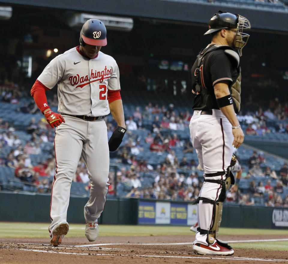 Washington Nationals' Juan Soto steps on home plate behind Arizona Diamondbacks' Stephen Vogt during the first inning of a baseball game Friday, May 14, 2021, in Phoenix. (AP Photo/Darryl Webb)