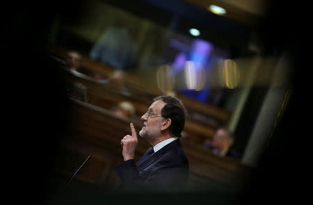 Spain's acting Prime Minister Mariano Rajoy delivers a speech during the investiture debate at the Parliament in Madrid, Spain October 27, 2016. The pattern across the frame is the reflection of light on a railing. REUTERS/Sergio Perez