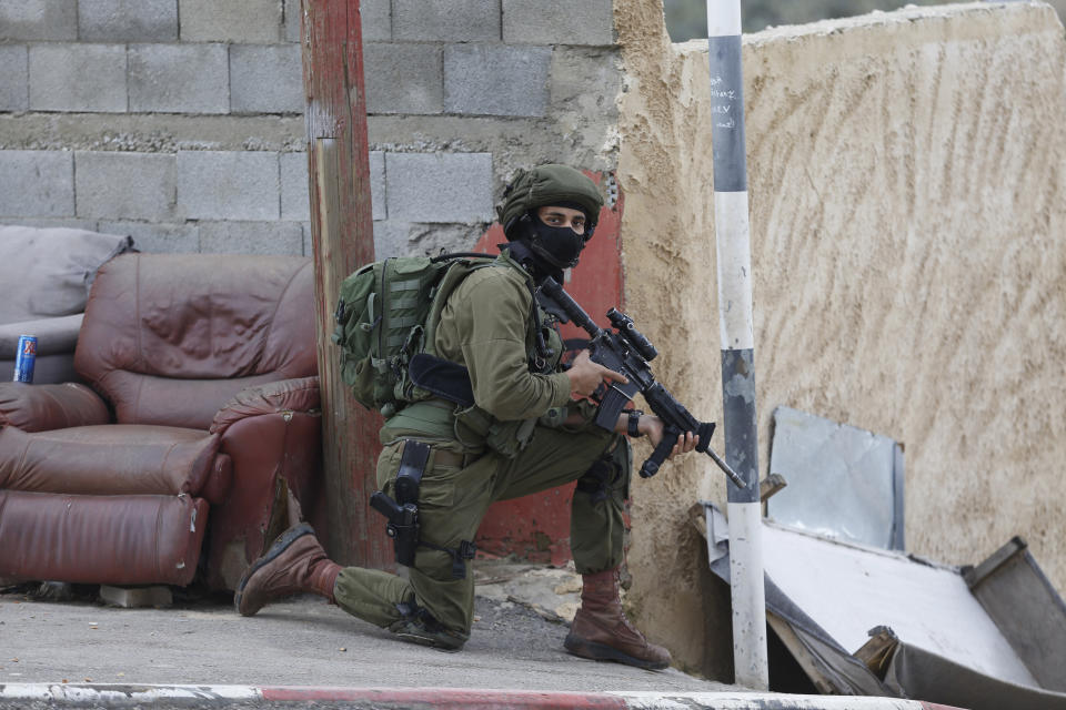 Israeli forces search for a Palestinian gunman in the village of Bruqin near the West Bank town of Salfit, Sunday, March 17, 2019. The Israeli military says a Palestinian killed an Israeli and seriously wounded two others in a West Bank shooting and stabbing spree before fleeing and setting off a massive manhunt. (AP Photo/Majdi Mohammed)