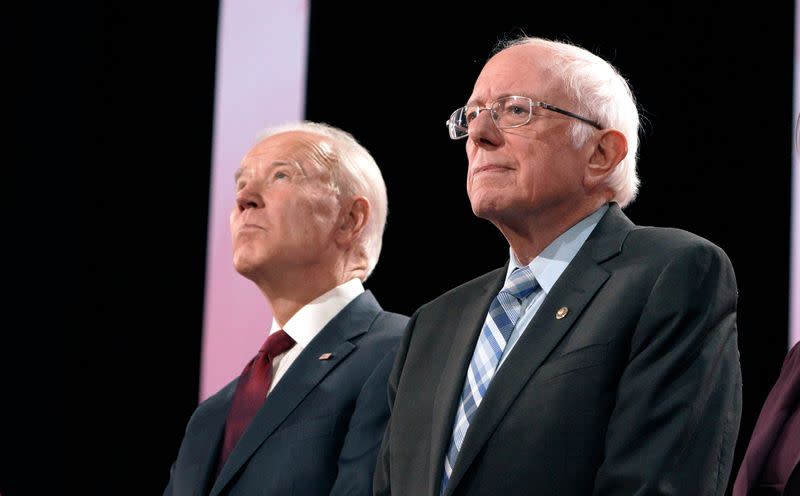 Former Vice President Joe Biden and Senator Bernie Sanders stand together on stage before the start of the sixth 2020 U.S. Democratic presidential candidates campaign debate at Loyola Marymount University in Los Angeles