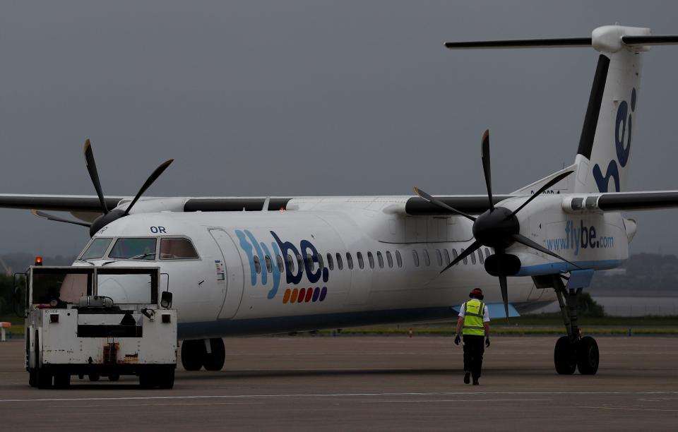 FILE PHOTO: An airport worker examines a flybe aircraft before it takes off from Liverpool John Lennon Airport in Liverpool northern England, May 19 , 2016. REUTERS/Phil Noble