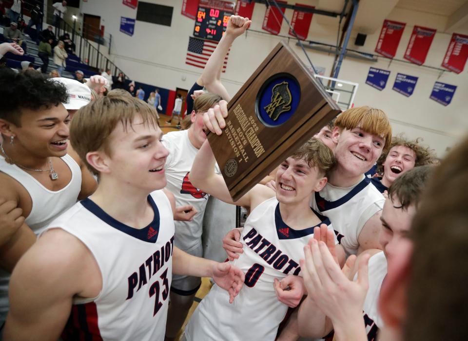 Appleton East's Tyler Borowski (0) raises the plaque after defeating Superior in a WIAA Division 1 boys basketball regional final Monday in Appleton.