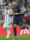 France's Kylian Mbappe runs past Argentina's Lionel Messi as he retrieves the ball after scoring his side's first goal during the World Cup final soccer match between Argentina and France at the Lusail Stadium in Lusail, Qatar, Sunday, Dec. 18, 2022. (AP Photo/Martin Meissner)