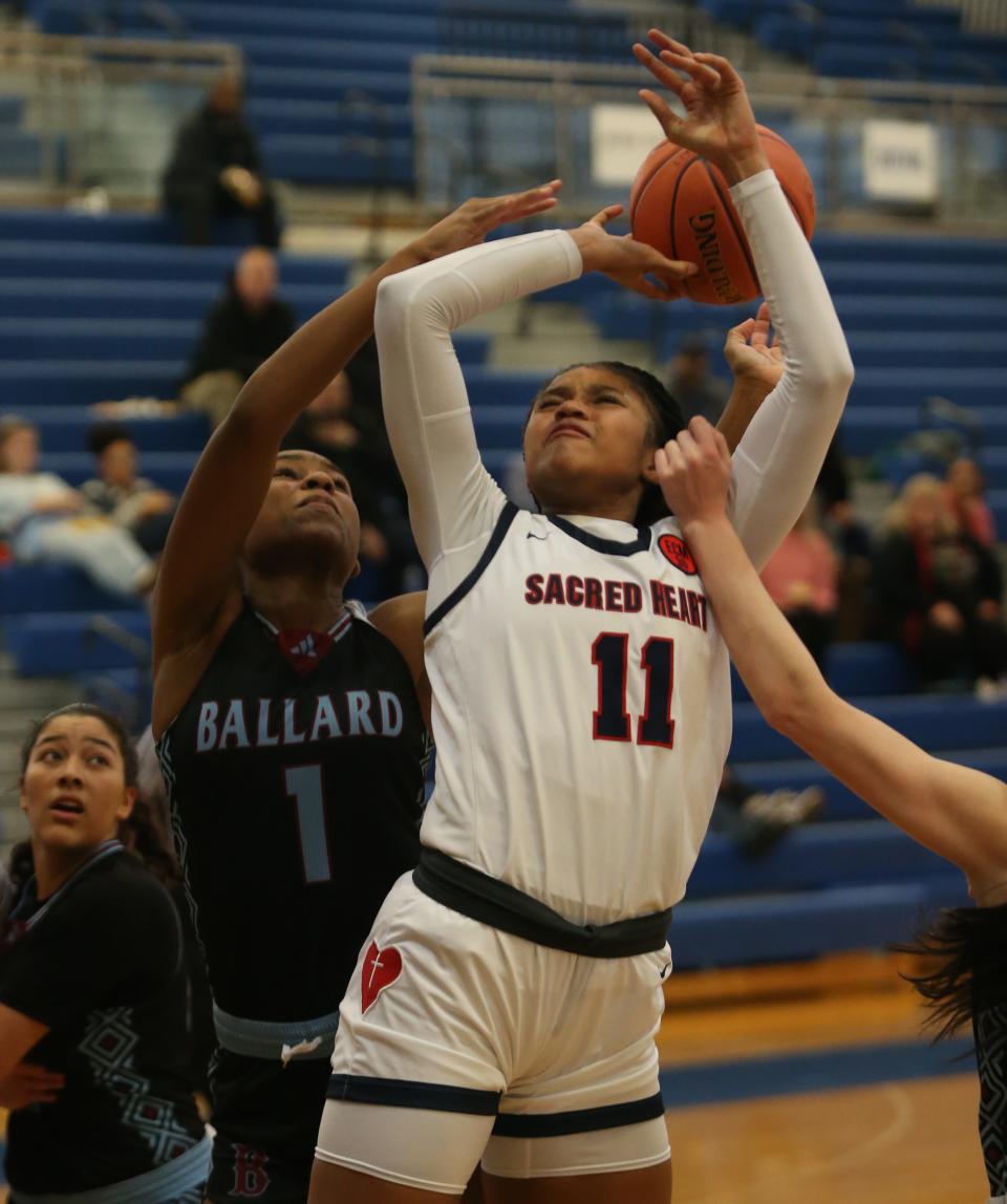 Sacred Heart’s ZaKiyah Johnson gets fouled as she tries to score against  Ballard’s Samari TaylorJan. 24, 2023