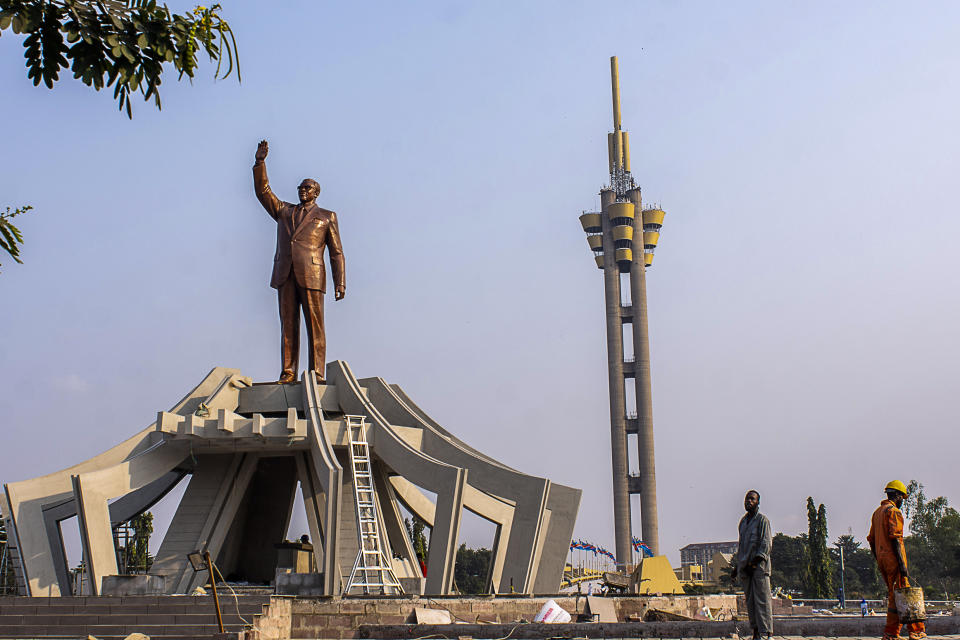 Workers stand by a memorial built to the memory of Democratic Republic of the Congo independence hero Patrice Lumumba, in Kinshasa, Monday, June 20, 2022. Belgian authorities returned a gold-capped tooth belonging to Lumumba, as the former colonial power continues to confront its bloody past and look toward reconciliation. The restitution of the relic took place after Belgium's King Philippe earlier this month expressed his "deepest regrets" for his nation's abuses in its African former colony, Congo, which is 75 times the size of Belgium.. (AP Photo/Samy Ntumba Shambuyi)