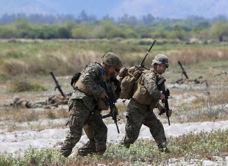U.S. soldiers help an injured colleague during the annual "Balikatan" (shoulder-to-shoulder) war games with Filipino soldiers on the shore of San Antonio, Zambales in northern Philippines April 21, 2015. REUTERS/Erik De Castro