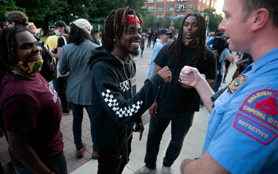 Raleigh Police Detective B.H. Winston, a veteran of 16 years, fist bumps Albert Fervily after having a conversation with Keesh Ormond, left and Dante Robinson following a rally at the Raleigh Municipal Building on Tuesday, June 2, 2020 in Raleigh, N.C. The photo took second place for general news photography among the state’s largest newspapers in the North Carolina Press Association’s annual awards.